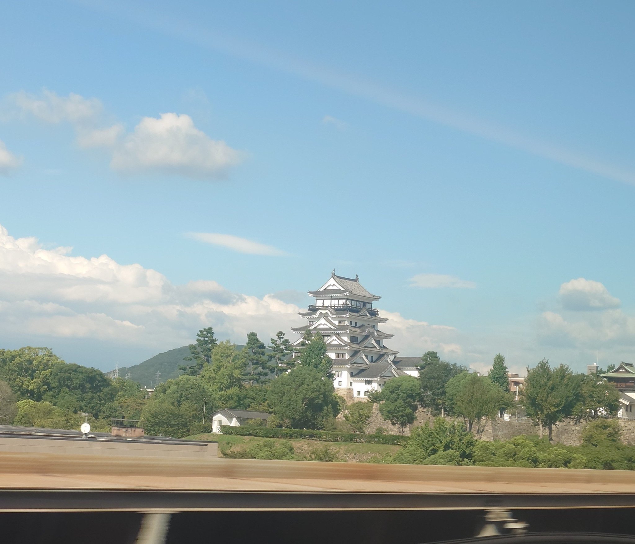 The white keep and stone walls of Fukuyama Castle seen from a Shinkansen window
