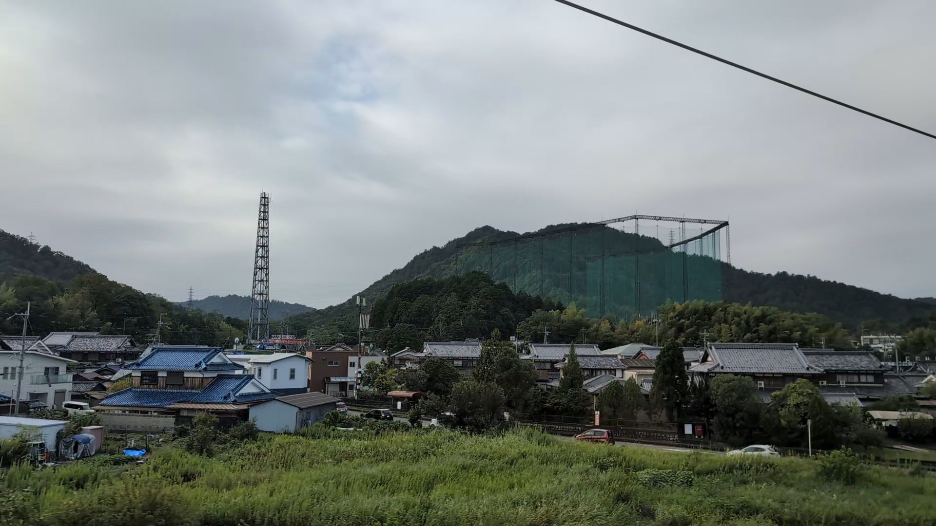 Altas redes verdes alrededor de un campo de prácticas de golf entre Maibara y Kioto