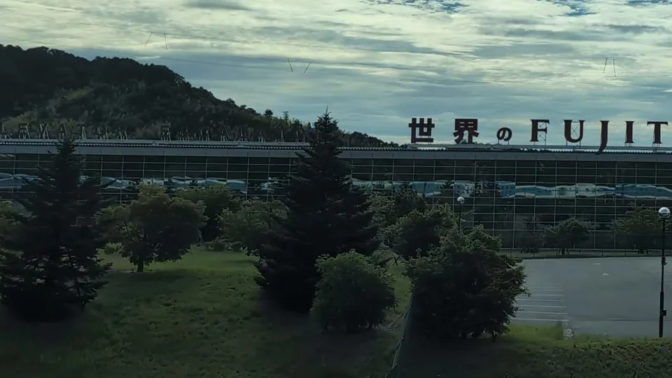 Close-up of the blue train reflected in the glass below the FUJITEC lettering
