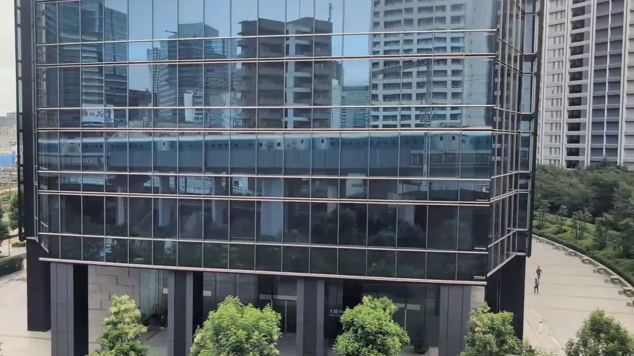 The Shinkansen reflected in a straight line across the glass of Osaki Garden Tower
