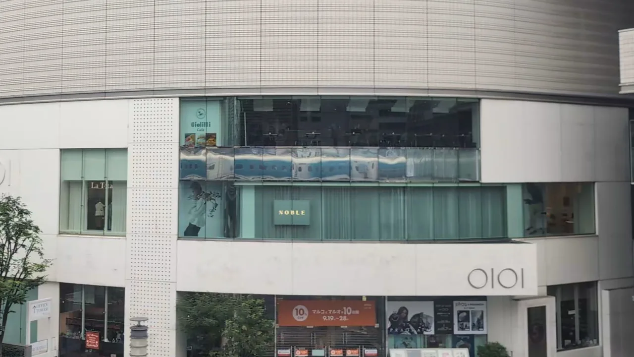 The Shinkansen reflected in the long strip of glass on the café floor of Yurakucho Marui
