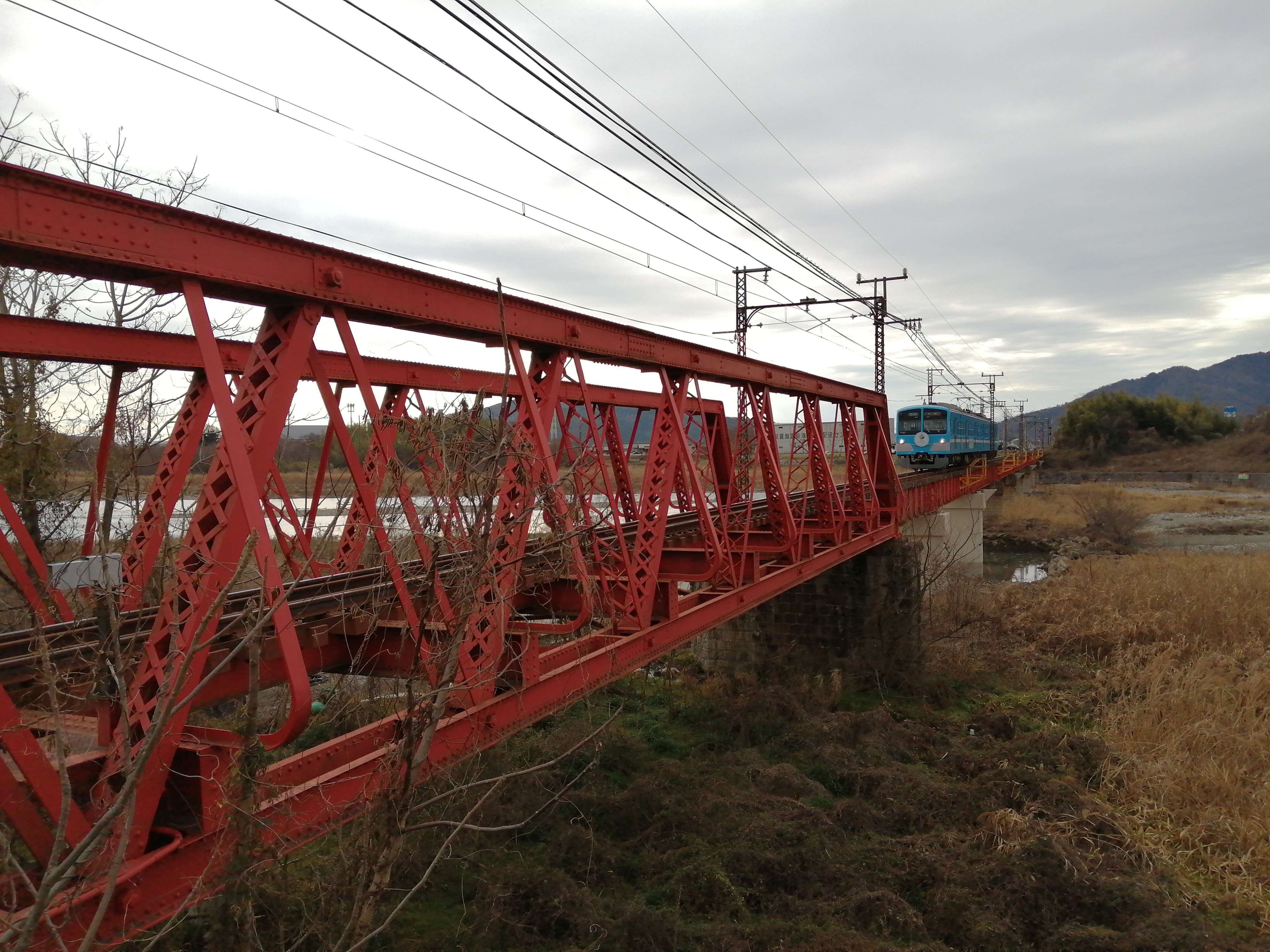 愛知川を渡る赤い鉄橋と近江鉄道の列車
