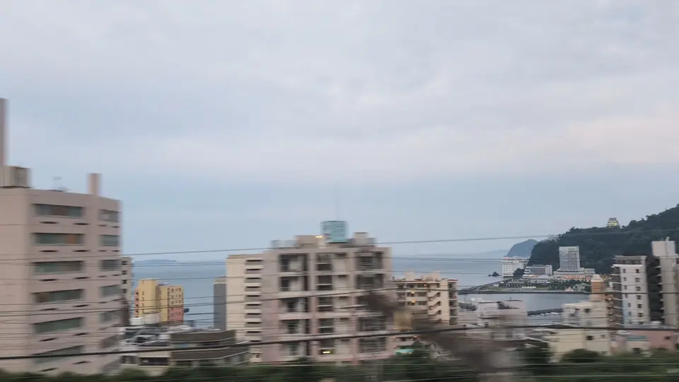 Atami Castle faintly lit on the evening hillside