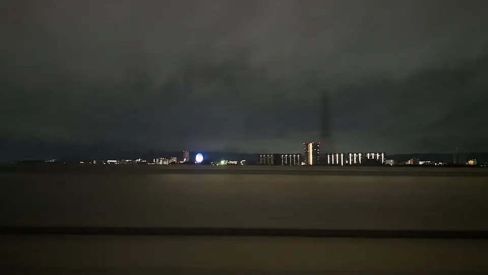夜の淀川越しに青白く光るひらパーの観覧車