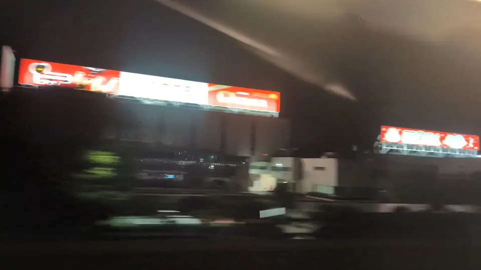 夜の車窓に光るロッテ滋賀工場のお菓子看板