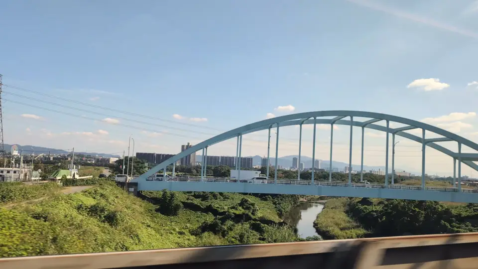 Il ponte blu Sagiuchi in primo piano, con la ruota di Hirakata Park all'estrema sinistra