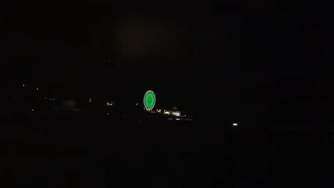 Fuji Sky View iluminada en verde al otro lado del río Fuji por la noche